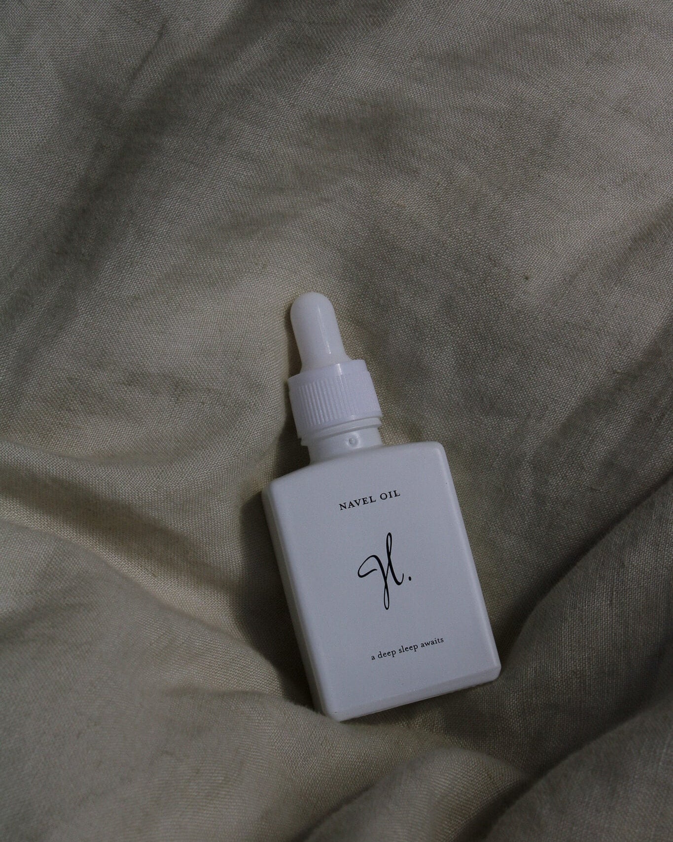 White dropper bottle on a textured beige surface